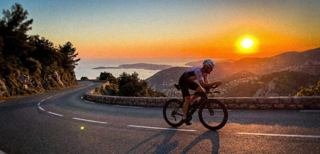 Triathlète sur vélo de contre-la-montre durant une course longue distance Ironman dans un paysage grandiose